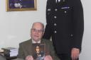 Return visit: Alex Rennie, seated underneath a portrait of himself when he was Chief Constable, with current Chief Constable, Paul West.